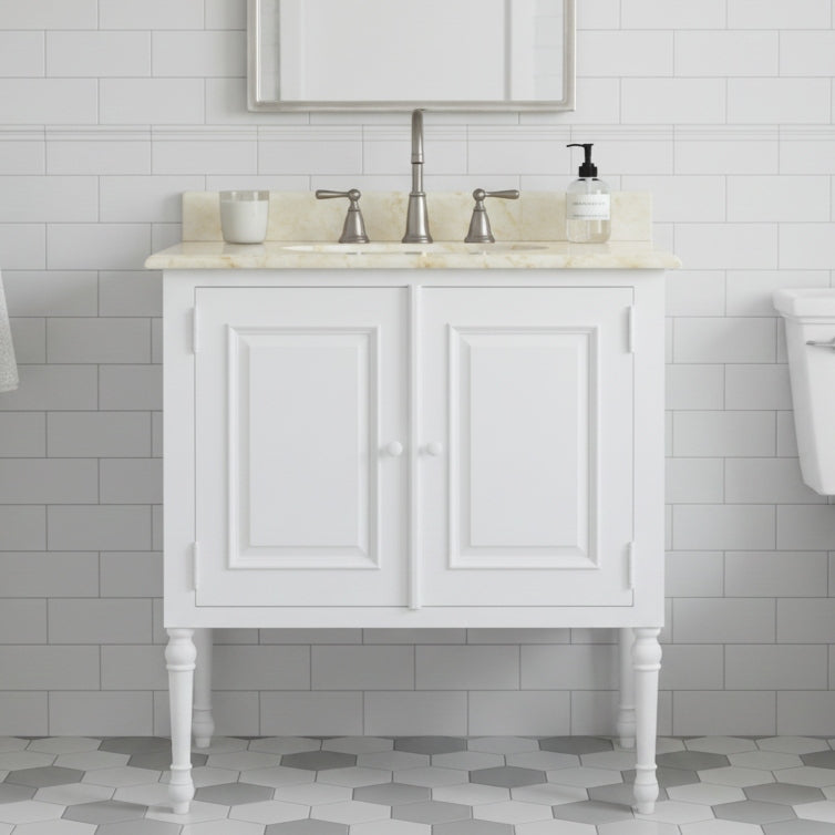 White bathroom vanity with marble countertop and sink against a tiled wall.