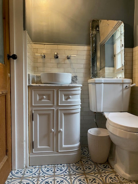 Bathroom with white vanity, toilet, and shower area.
