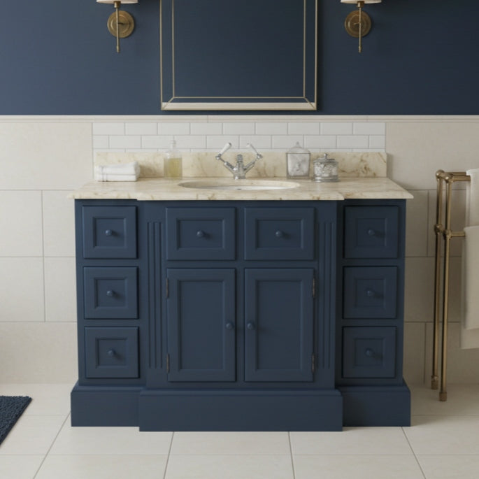 Navy blue bathroom vanity with marble countertop against a blue wall.