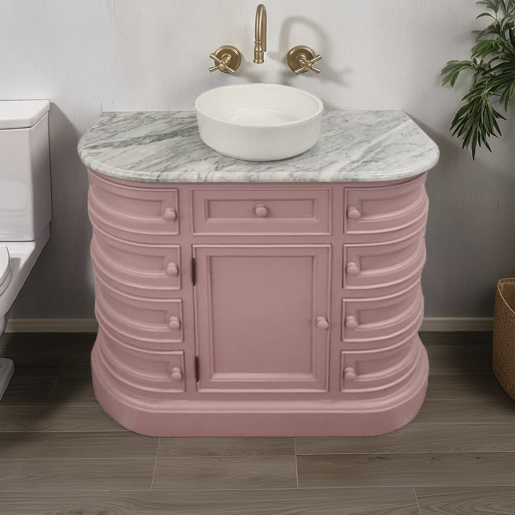 Pink bathroom vanity with marble countertop and gold faucet