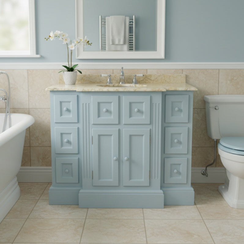 Bathroom with a light blue vanity unit, sink, and toilet.