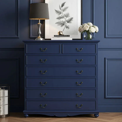 Navy blue dresser with decorative items against a blue wall