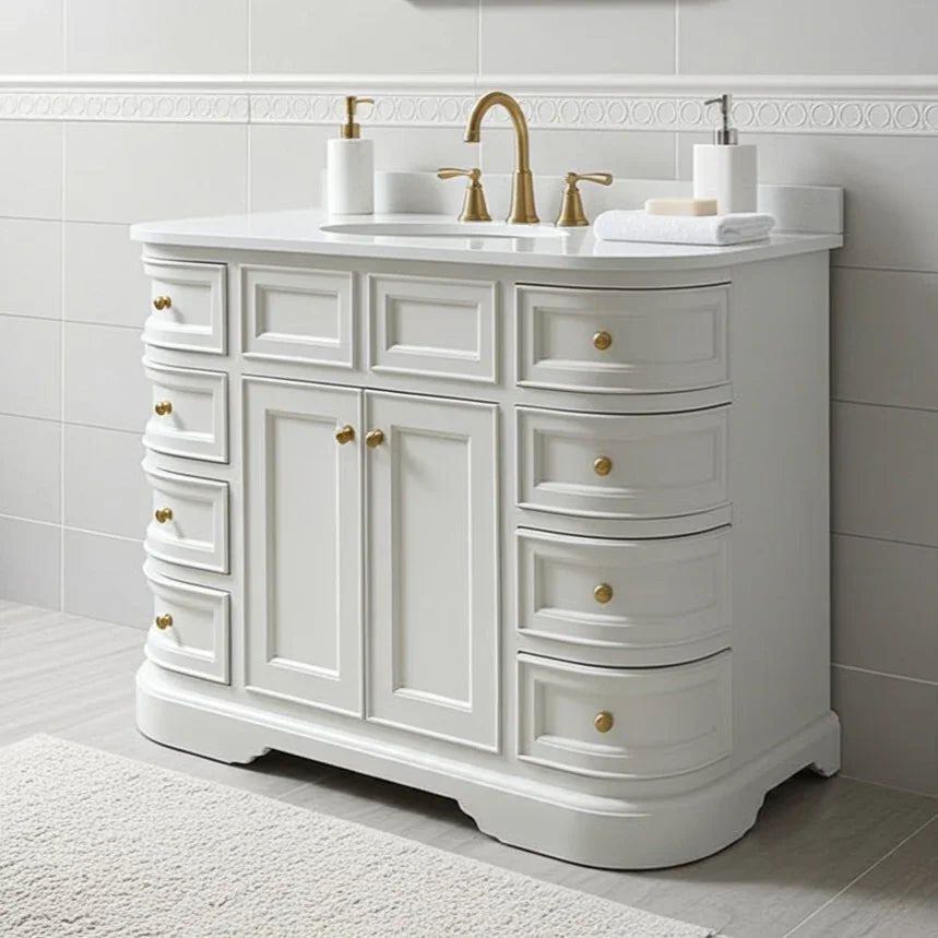 White bathroom vanity with gold fixtures against a tiled wall.