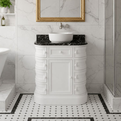 Bathroom vanity with black marble countertop and white sink against a marble wall.