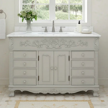 Decorative bathroom vanity with marble countertop and sink in a bright room.