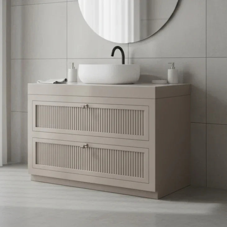 Bathroom vanity with round mirror and sink on a tiled wall.