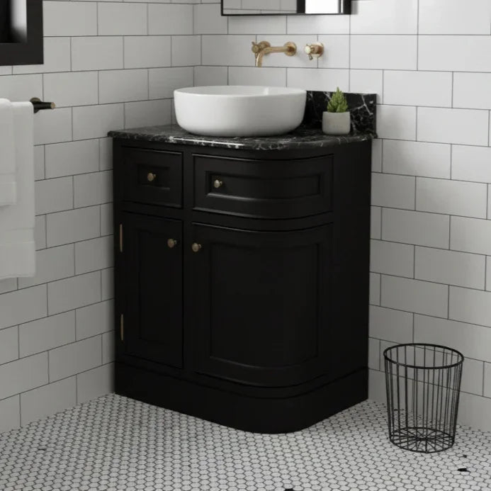 Bathroom with black vanity unit, white sink, and tiled walls.