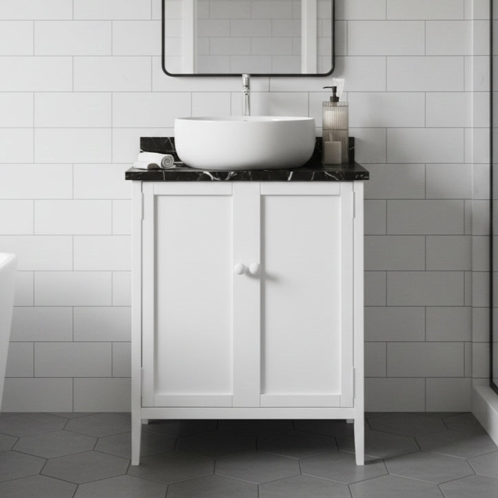 Bathroom vanity with a white sink and black countertop against a tiled wall.