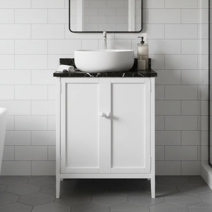 Bathroom vanity with a white sink and black countertop against a tiled wall.