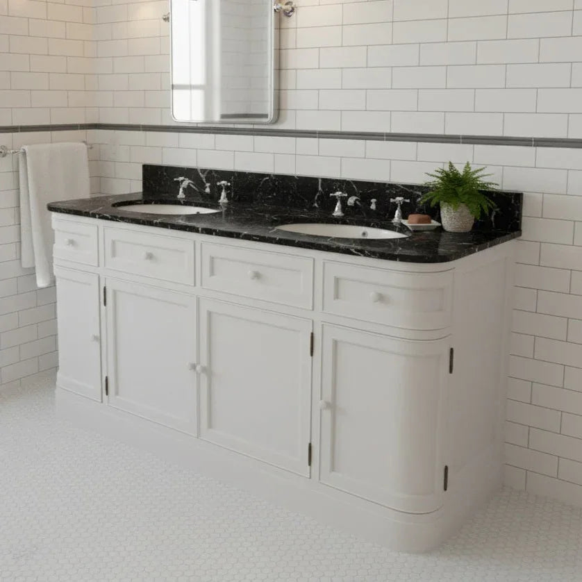 Bathroom vanity with black countertop and white cabinets, featuring a mirror above.