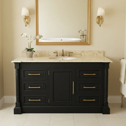 Bathroom vanity with marble countertop, sink, and gold fixtures against a beige wall.
