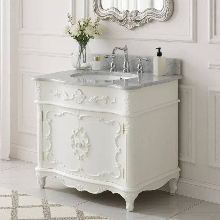 White ornate bathroom vanity with marble countertop, sink, and decorative mirror.