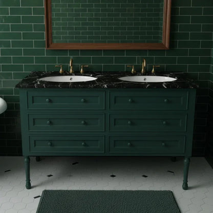 Bathroom vanity with black marble top and green tiled walls.