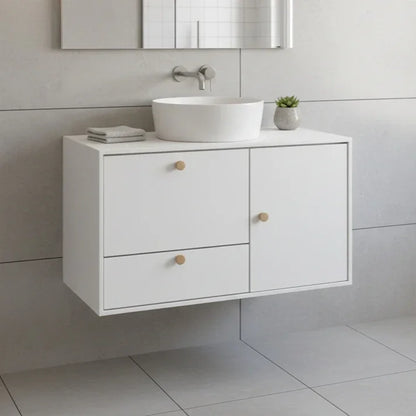 Bathroom vanity with white sink and drawers against a tiled wall.