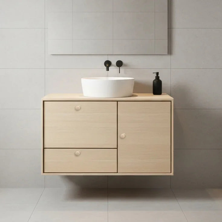 Bathroom vanity with a white sink against a tiled wall.
