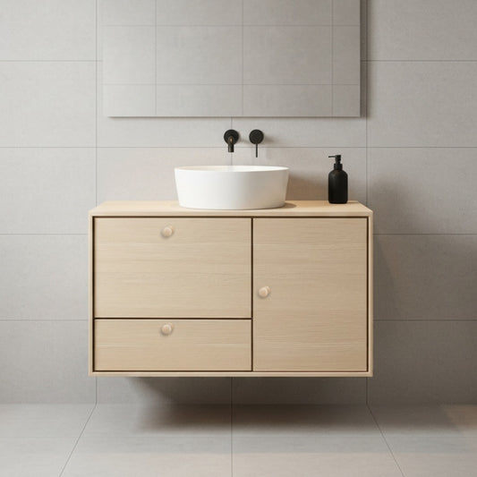 Bathroom vanity with a white sink against a tiled wall.