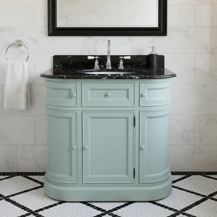 Curved bathroom vanity unit with black marble top in a white bathroom