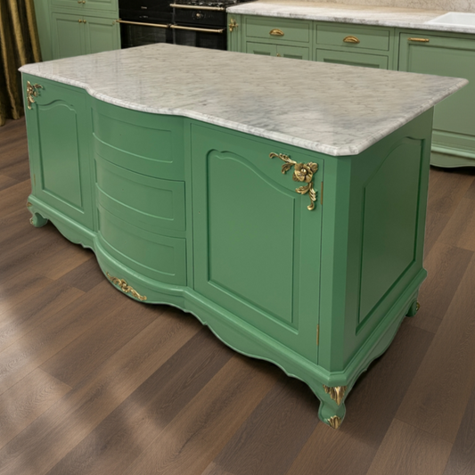 Green kitchen island with marble countertop in a well-lit kitchen.