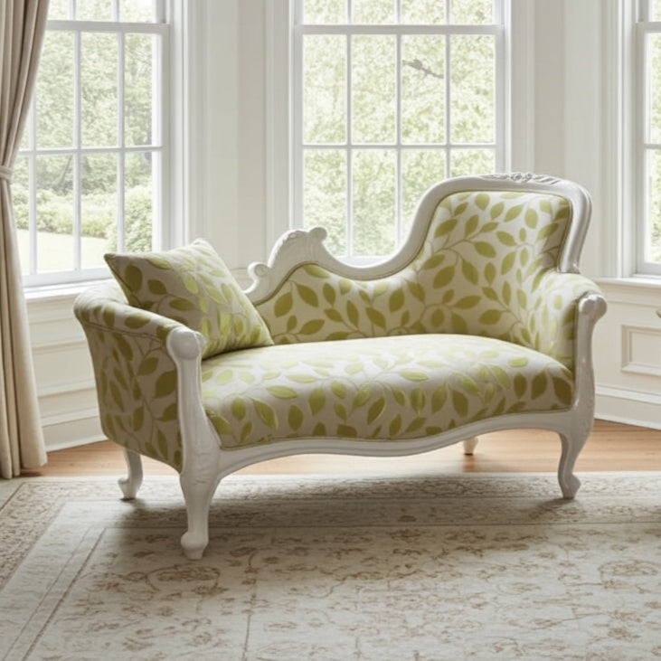 Decorative chaise lounge with leaf pattern in a bright room with large windows.