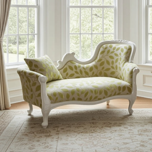 Decorative chaise lounge with leaf pattern in a bright room with large windows.