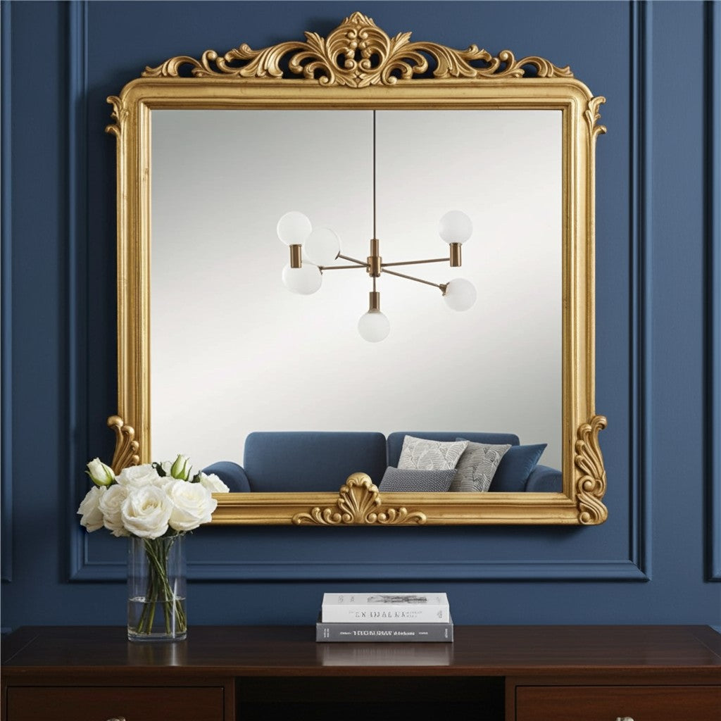 Decorative gold-framed mirror on a blue wall with a chandelier reflection.
