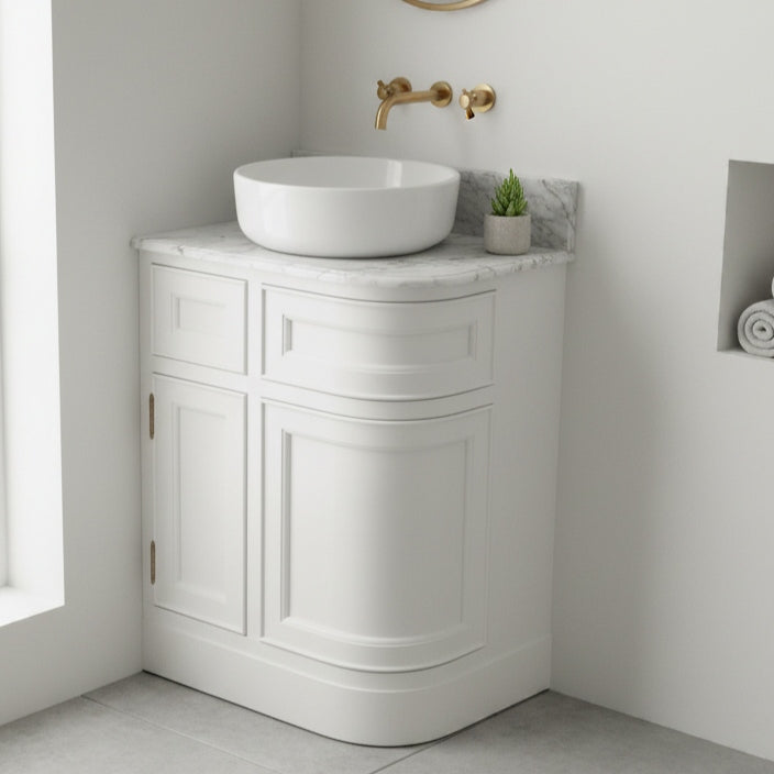 Corner bathroom vanity with white sink and gold faucet in a modern bathroom setting.