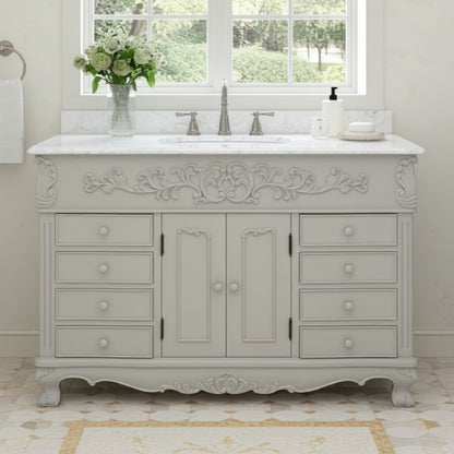 Decorative bathroom vanity with marble countertop and sink in a bright room.