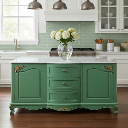 Green kitchen island with white flowers in a vase, set against a green tiled wall.