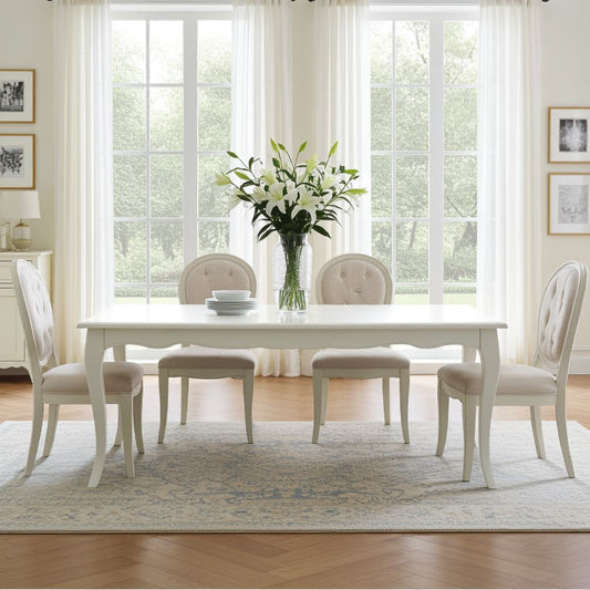 Dining room with a white table and chairs, featuring a vase of flowers.