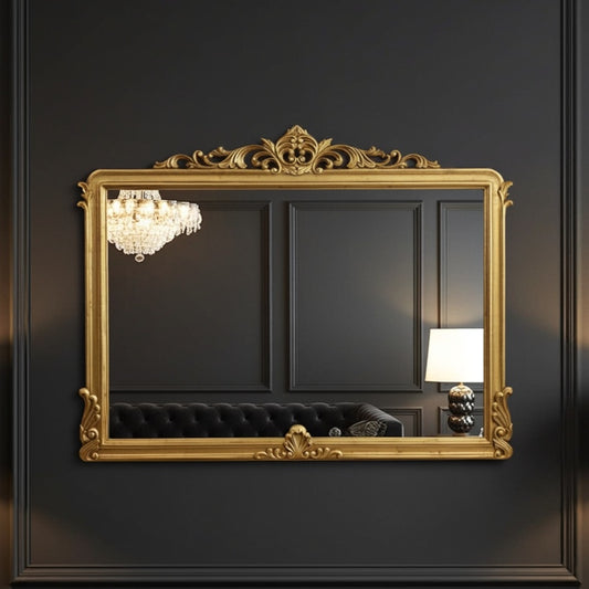 Decorative gold-framed mirror on a dark wall with a chandelier and lamp visible.