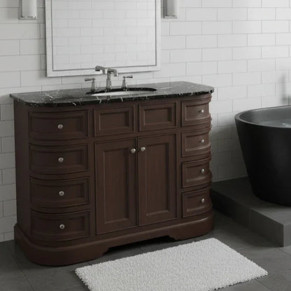 Bathroom vanity with marble countertop, sink, and dark wood finish in a tiled bathroom.