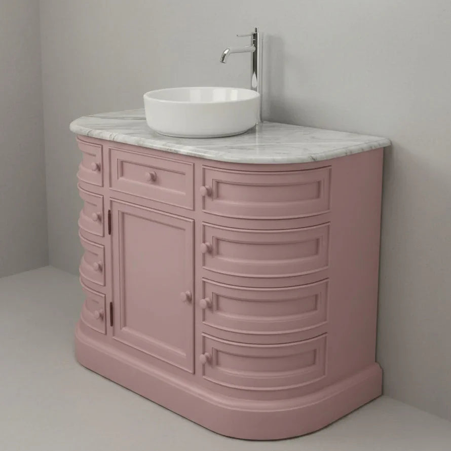 Pink bathroom vanity with white sink and marble countertop against a gray wall.