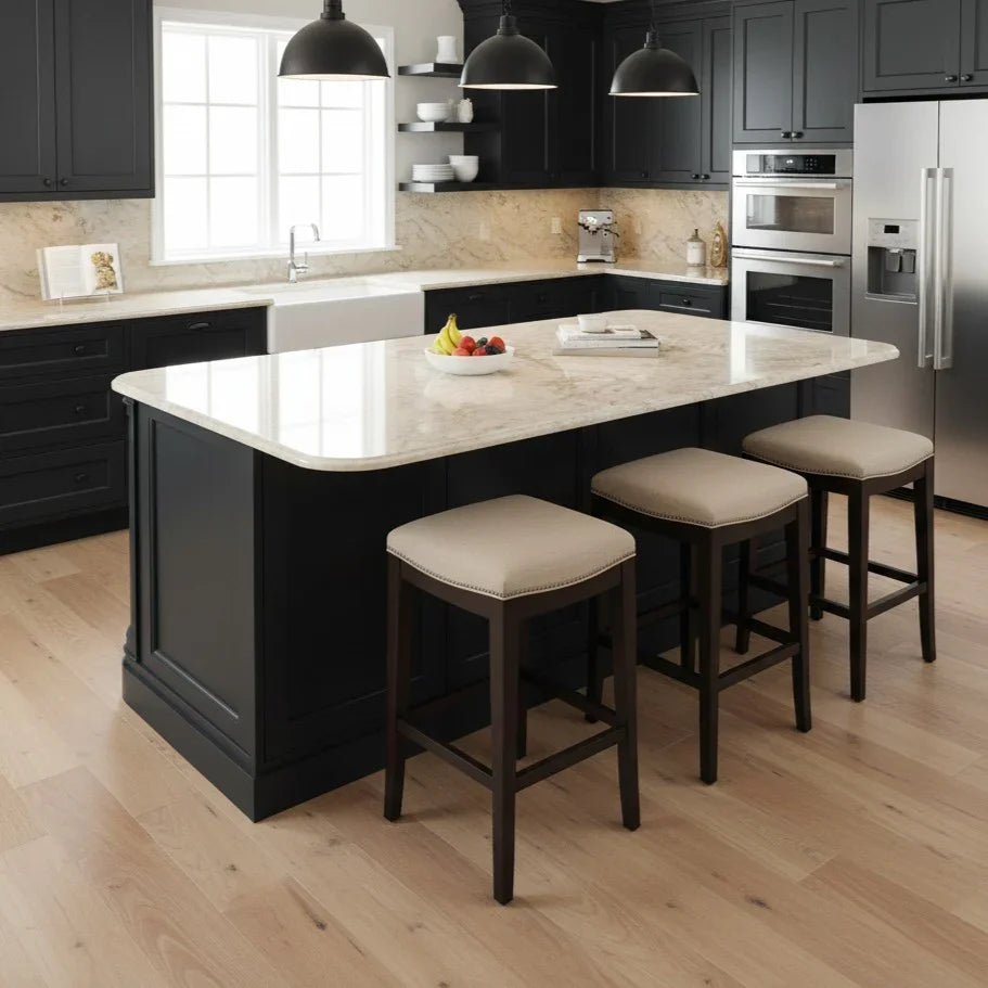Modern kitchen with black island and stools, stainless steel appliances, and light wood flooring.