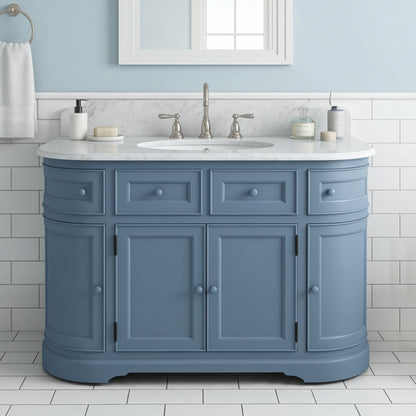 Blue bathroom vanity with white countertop and fixtures in a tiled bathroom.