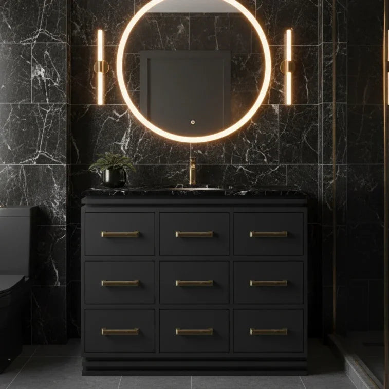 Bathroom vanity with round illuminated mirror and black marble walls