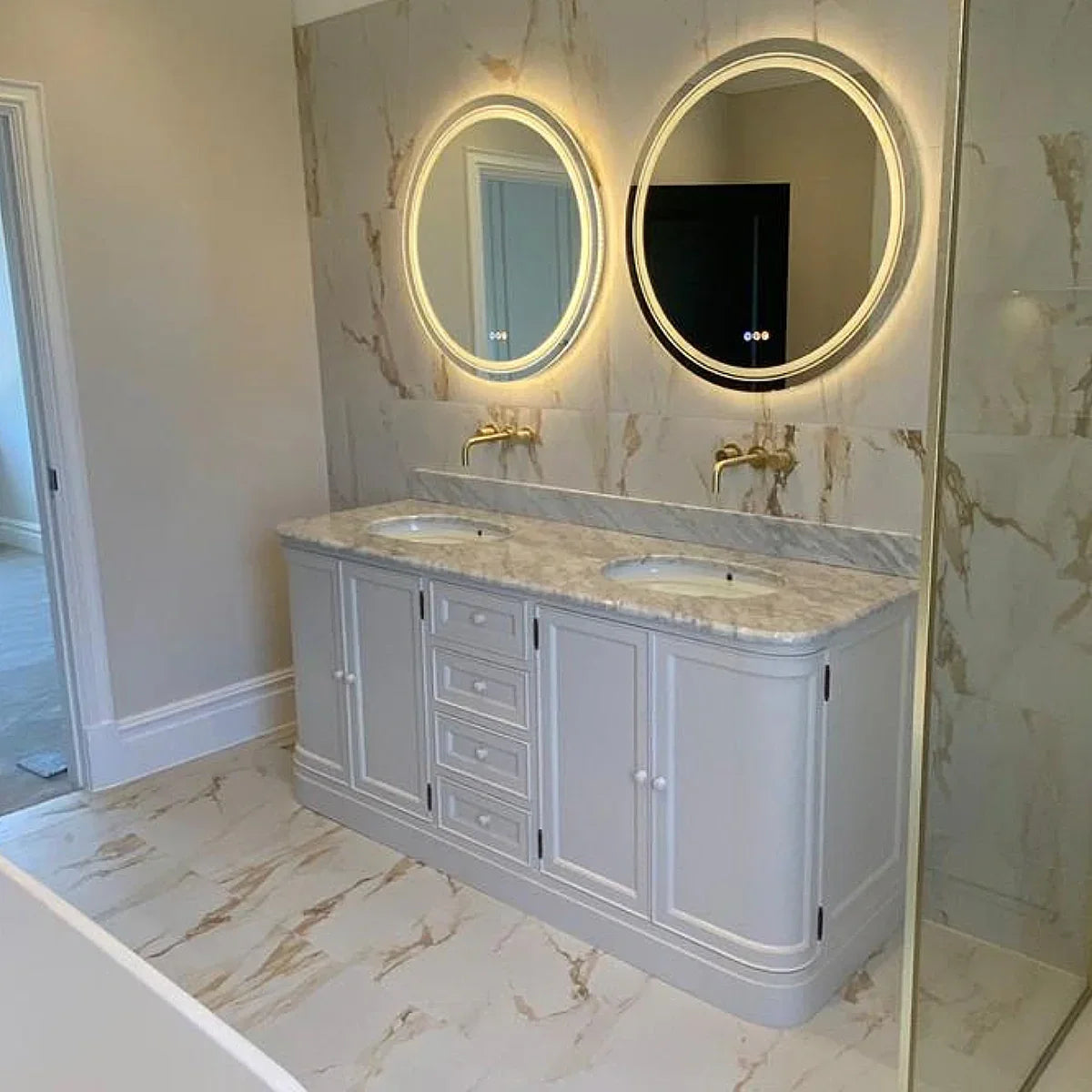 Bathroom vanity with round mirrors and marble countertop