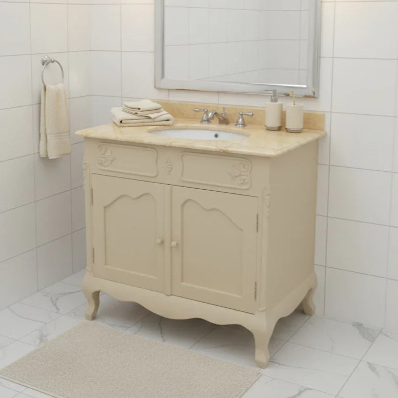 Beige bathroom vanity with marble countertop and sink in a tiled bathroom.