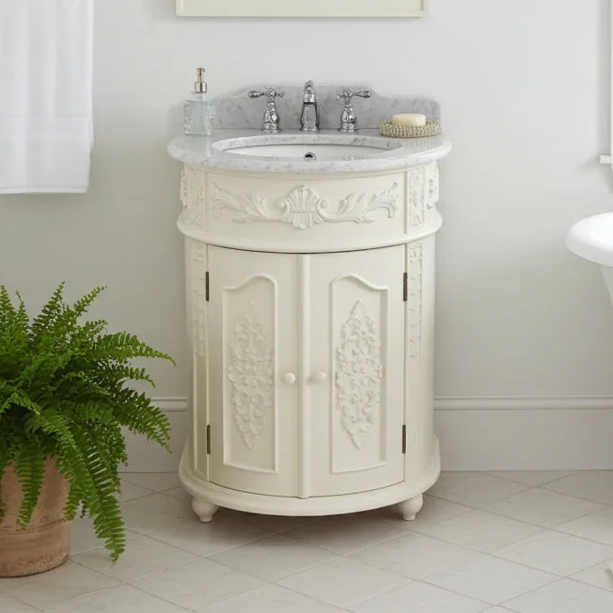 Vintage-style white bathroom vanity with marble countertop and faucet, potted fern on the side.