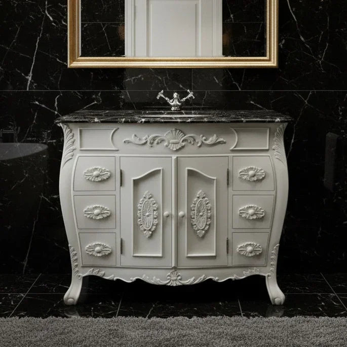 Decorative white vanity with marble top against a black marble wall.