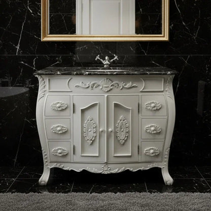 Decorative white vanity with marble top against a black marble wall.