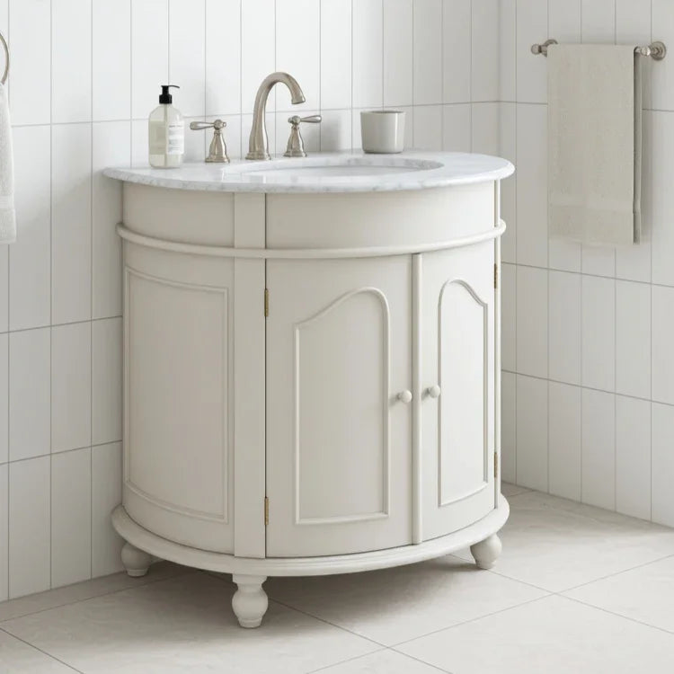 White bathroom vanity with marble countertop and sink in a tiled bathroom.
