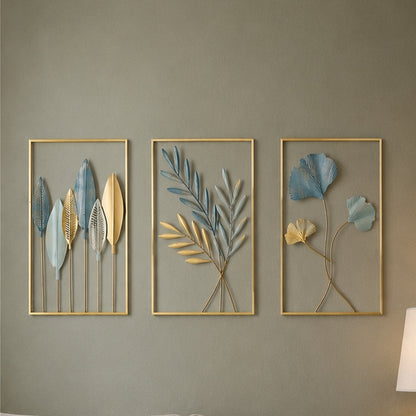 Three framed wall art pieces with leaf designs on a gray wall.