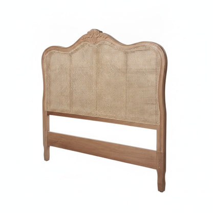 A wooden bed headboard with a natural woven cane center panel and a carved crest on the top, shown against a plain white background.