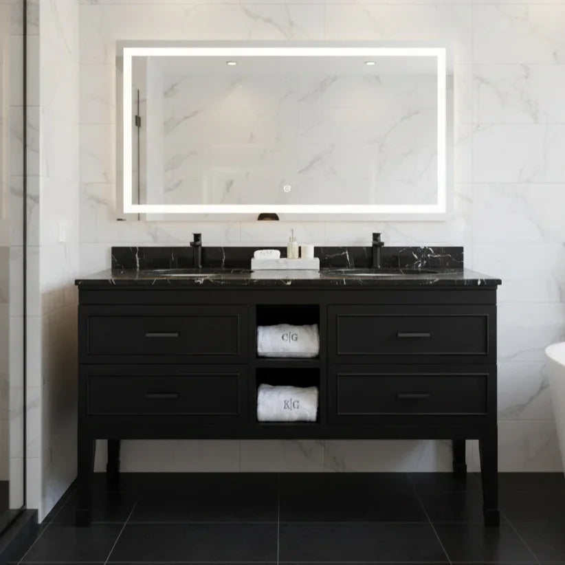 Bathroom vanity with black marble countertop and illuminated mirror.